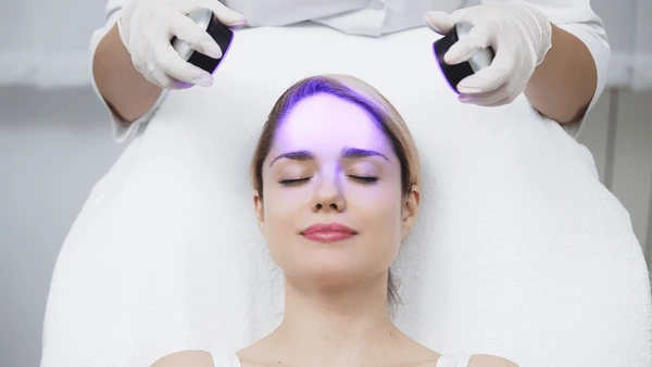 cosmetologist performs led light therapy 600nw 2518602191